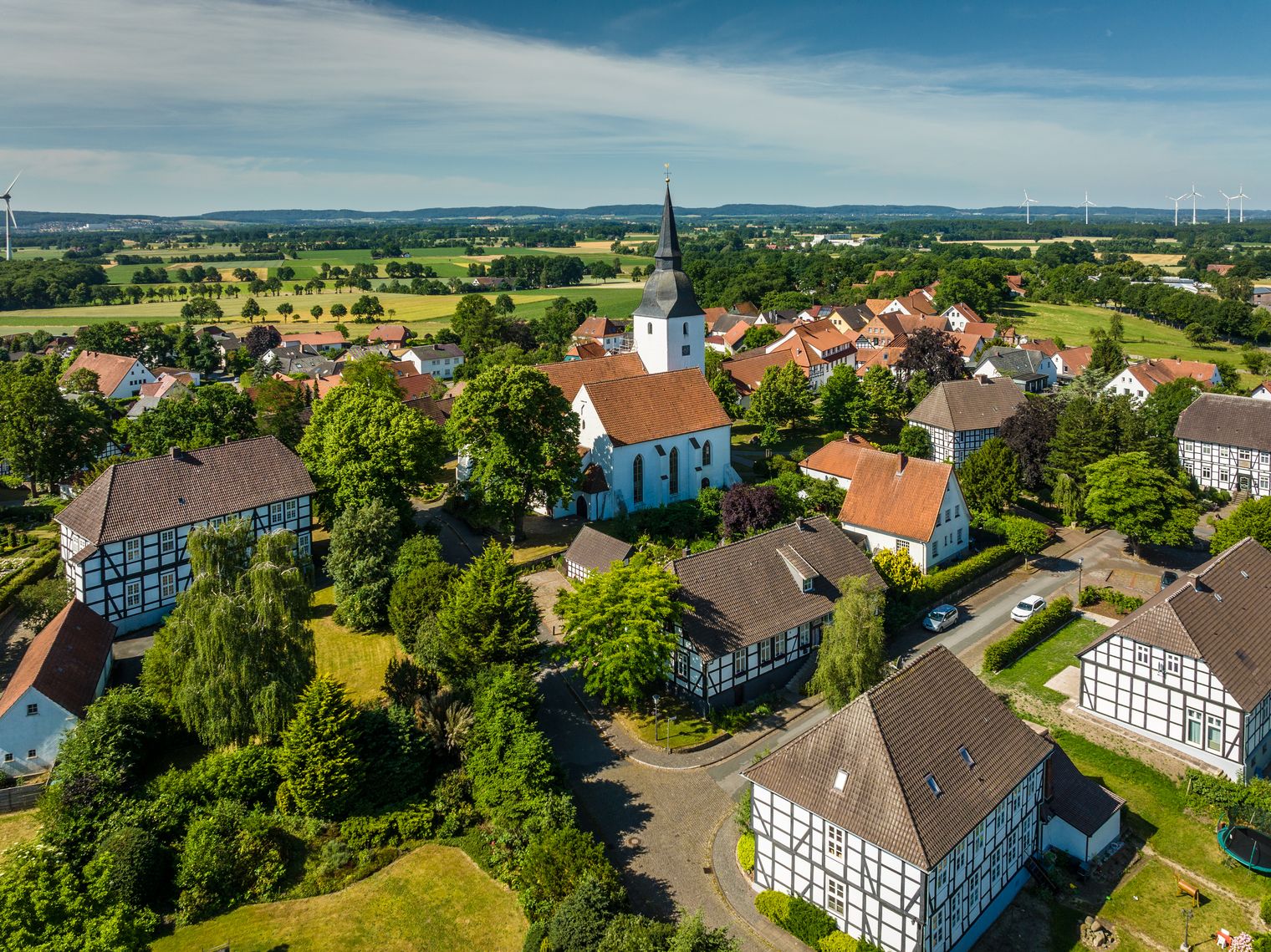 Blick über historische Fachwerkhäuser und die Stiftskirche in Levern, umgeben von grüner Landschaft.