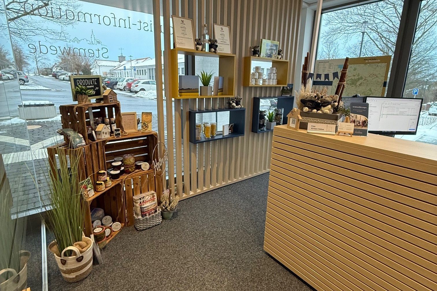 Innenraum der Tourist‑Info Stemwede mit Tresen, Regalen und regionalen Produkten.